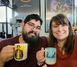 Mrs. Claros and her husband holding mugs and smiling