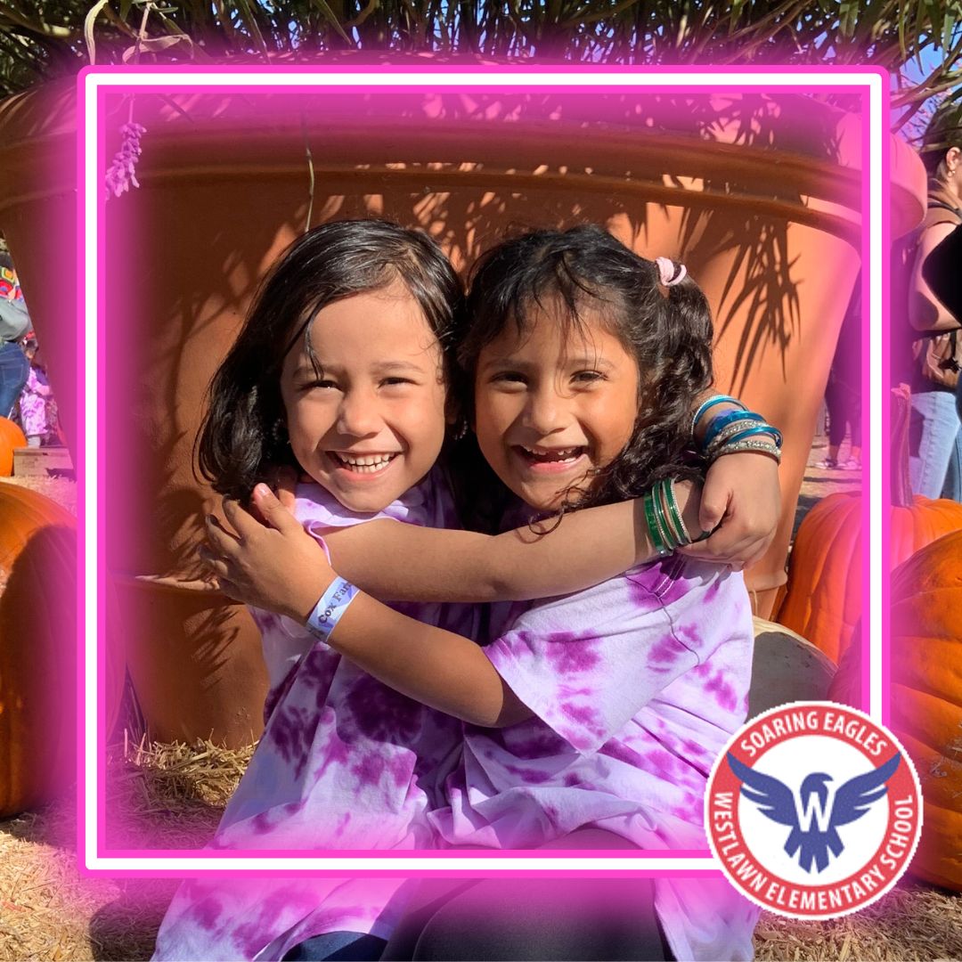 two students embrace each other and smile for the camera