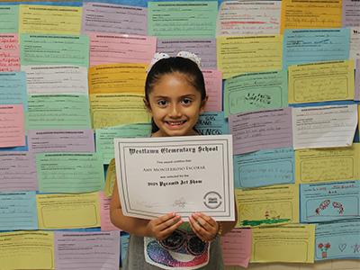 Young girl holding up certificate
