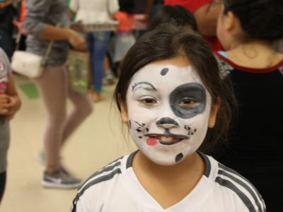 A student with a dog face painted on her