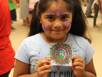 Student with painted face and art she created