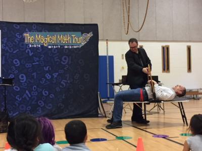 Assistant principal pretends to scream as he is sawed in half for magic trick