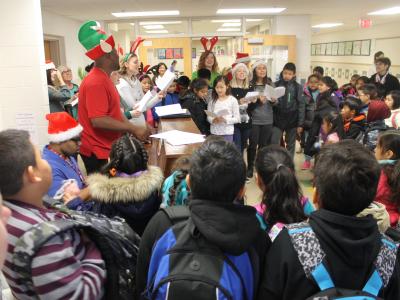 Students surround the carolers.