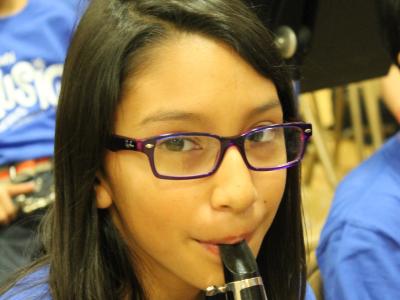 Girl with clarinet gives a shy smile for camera
