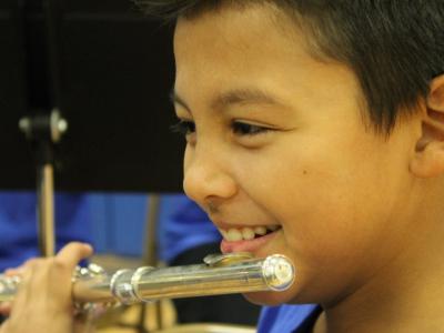 A big smile as a flutist waits to play (boy)