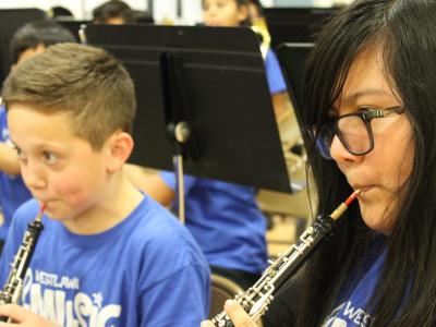 Two students playing clarinets (boy and girl)