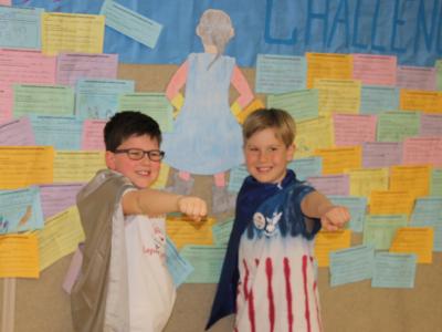 Two student super kindness heroes striking a super hero pose