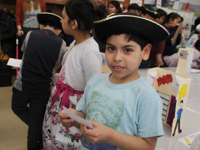 Boy in tricorn hat holds his index card of notes ready for a visitor