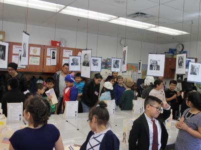 A crowd of visitors moves around the classroom