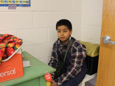 Hispanic boy with a box of fresh picked produce.