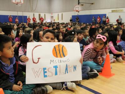 Student holds "Go Westlawn" sign.