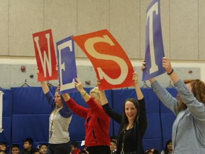 Teachers hold "West" signs