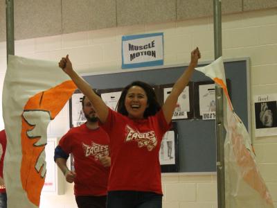 Ms. Urano breaks through banner with arms raised in spirit