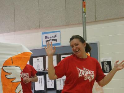 Instructional assistant gives a spirit hop through the banner