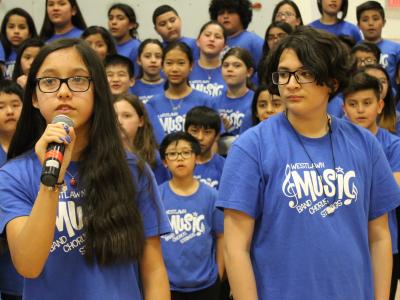 Female Chorus student speaks into microphone