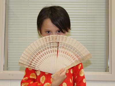 Girl with fan in front of her face