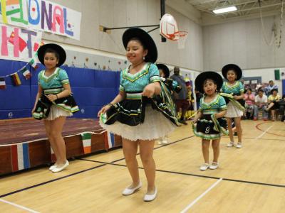 Students in Green hispanic dresses dance for the crowd
