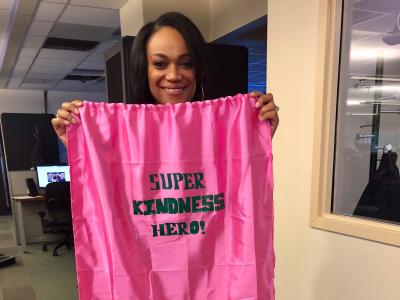 Ms. Green holding up her pink super kindness hero cape.